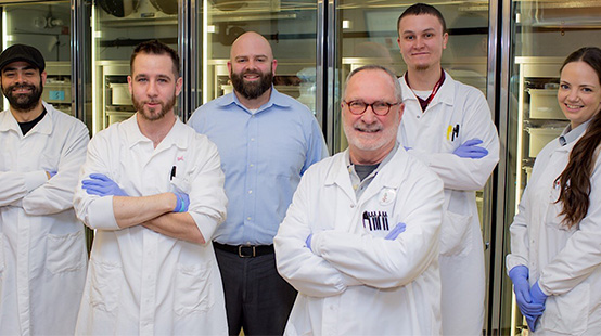 Rhode Island Blood Center laboratory staff in lab coats and leadership in business attire.